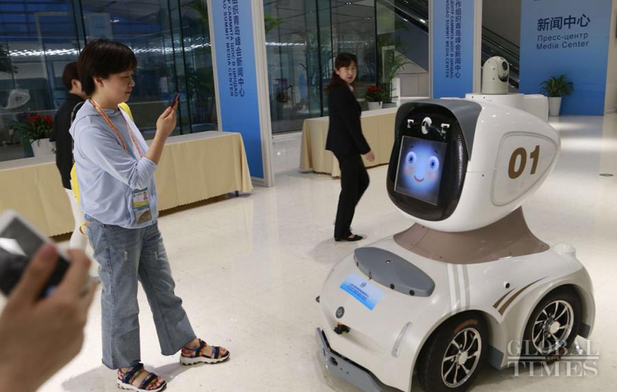 A robot patrols the media center of the 18th Shanghai Cooperation Organization Summit on Thursday. (Photo: Li Hao/GT)

With the approach of the Shanghai Cooperation Organization (SCO) Qingdao Summit, volunteers provide assistance for international journalists at the media center that formally opened on June 6. Its services include transportation, medical care and security. The media center also boasts welcome robot “66”, security robot “Haihai” and delivery robot “Dian Xiaoer.” Security robot “Haihai” can carry out 24-hour autonomous patrols and follow-up surveillance of suspicious persons and items. It can also scold people who walk on the grass and post advertisements.
