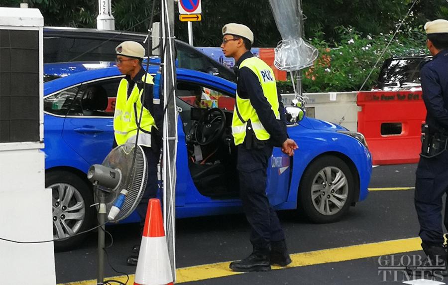 Singaporean police check the passing vehicles outside the St. Regis hotel where DPRK leader Kim Jong-un has stayed on Sunday. (Photo: Yang Sheng/GT)