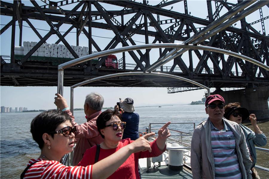 Tourists view the DPRK from the Yalu River in Dandong. (FRED DUFOUR/FOR CHINA DAILY)

Speculation

Zhang added that local people have not reacted to speculation in some parts of China that Dandong could be a future Shenzhen－the city in Guangdong province that was the country\'s first special economic zone. The speculation erupted after Kim announced plans to focus on economic development during a meeting in the DPRK on April 20.

\