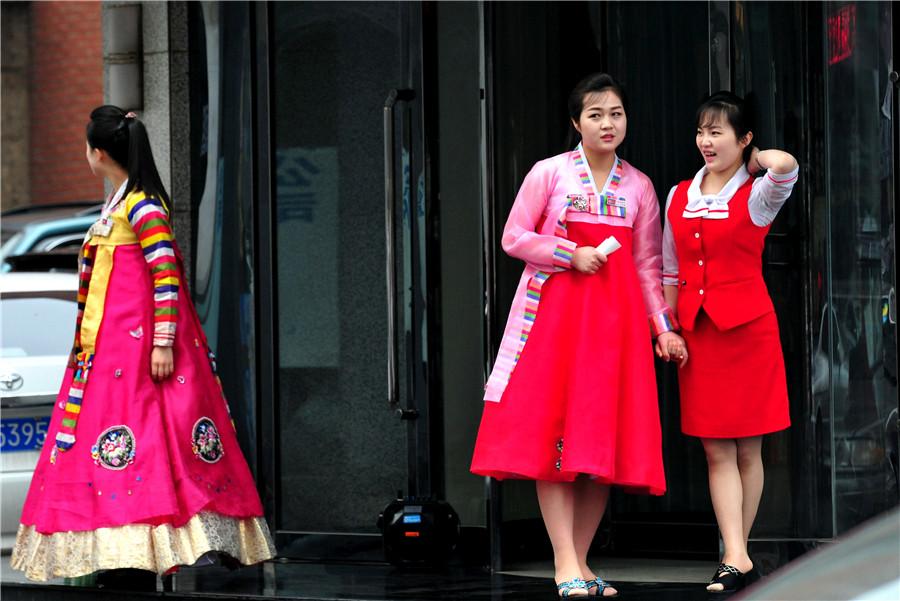 Restaurant waitresses dressed in Korean ethnic garb ready to welcome customers in Dandong, Liaoning province, on May 1. (YU HAIYANG/FOR CHINA DAILY)

Gaoli Street is one of the most popular places in Dandong for people from the two countries to meet and discuss business opportunities. On Zhou\'s desk, small Chinese and DPRK national desk flags flank a collection of books about Kim Il-sung, the DPRK\'s founder who was Kim Jongun\'s grandfather.

Printed in the DPRK, the books were presented to Zhou by his counterparts in the country. He has studied the volumes, which are written in Chinese, carefully to glean hints that would help him decode the mindset of the country\'s leaders.

Many people find the DPRK a mysterious place－but Zhou is not one of them. He travels to the country frequently and regards it as just another foreign destination with plenty of business potential.

\