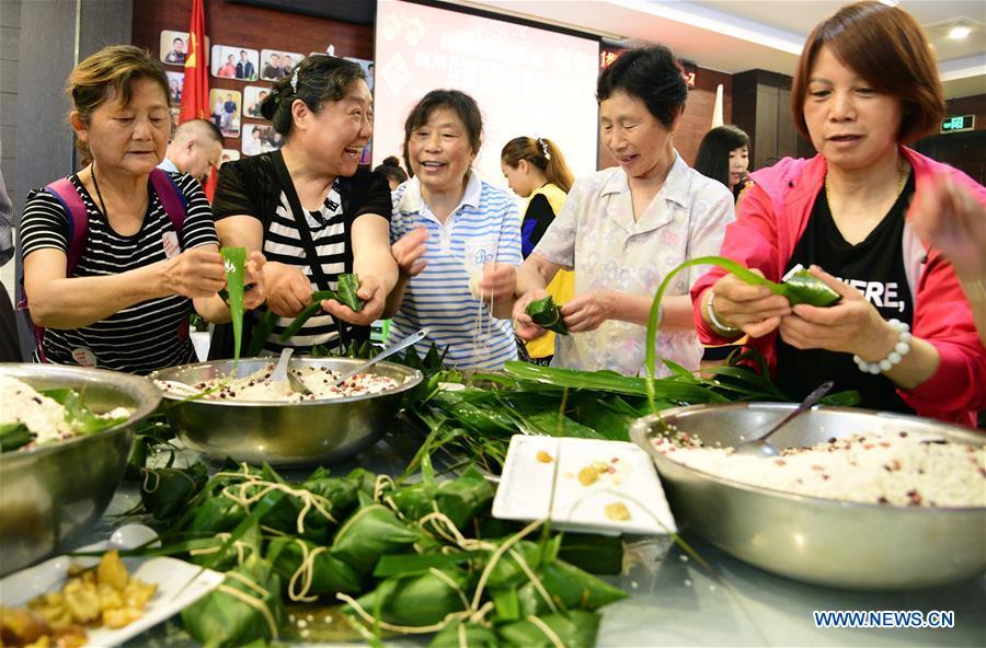 Volunteers make zongzi, a pyramid-shaped dumpling made of glutinous rice wrapped in bamboo or reed leaves, for the elderly persons of no family to celebrate the Duanwu Festival at a community in Zhenjiang City, east China\'s Jiangsu Province, June 11, 2018. (Xinhua/Shi Yucheng)