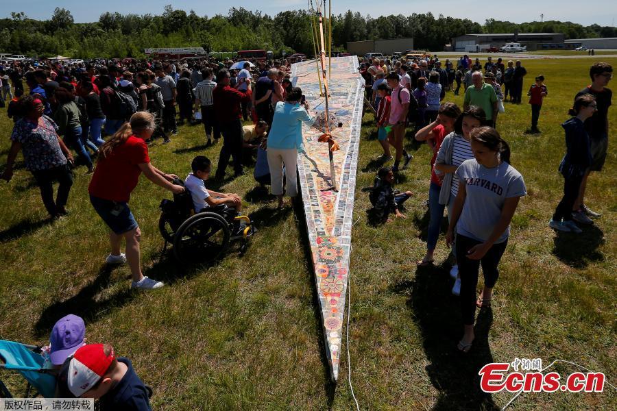 Photo taken on June 12, 2018 shows a massive paper airplane in Fitchburg, U.S. The 64-foot-long plane weighing in at over 1,500 pounds was put together by Project Soar at the Revolving Museum of Fitchburg. Creators of the paper airplane hope it will become a new Guinness World Record. (Photo/Agencies)