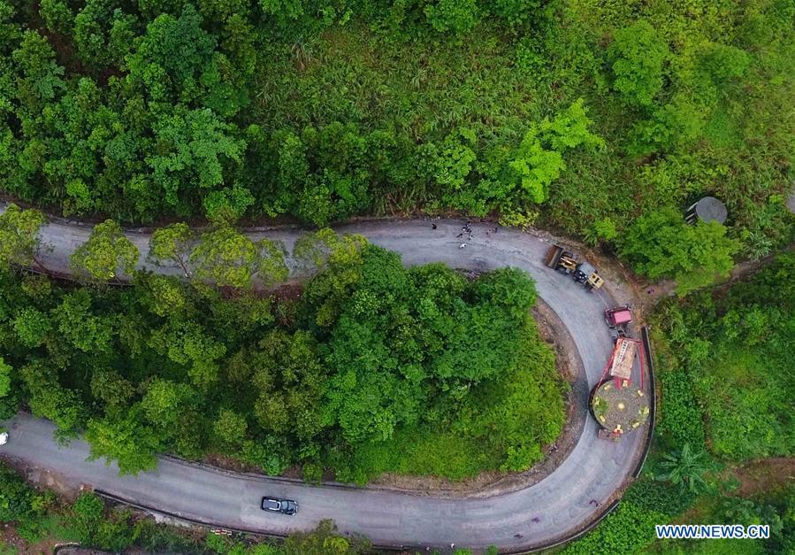A truck carrying a giant bronze drum runs on a mountain road in Huanjiang Maonan Autonomous County, south China\'s Guangxi Zhuang Autonomous Region, June 12, 2018. The diameter of the drum is over six meters. It will be conveyed to Huazhumao plaza in Huanjiang. (Xinhua/Gao Dongfeng)