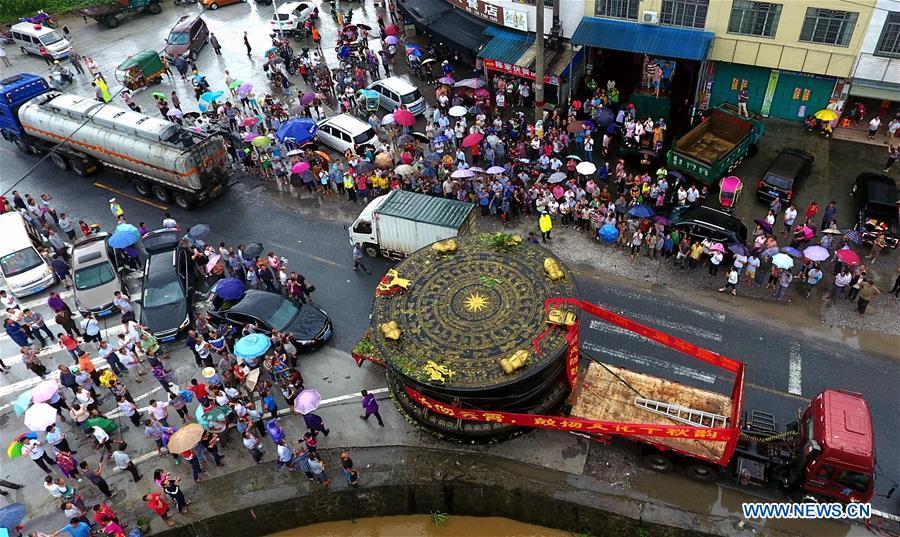 A truck carrying a giant bronze drum runs on a road in Huanjiang Maonan Autonomous County, south China\'s Guangxi Zhuang Autonomous Region, June 12, 2018. The diameter of the drum is over six meters. It will be conveyed to Huazhumao plaza in Huanjiang. (Xinhua/Gao Dongfeng)