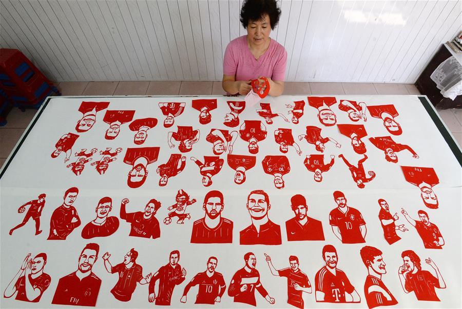 Craftswoman Feng Shiping makes paper-cutting works to greet the FIFA World Cup in Handan, north China\'s Hebei Province, June 12, 2018. (Xinhua/Hao Qunying)