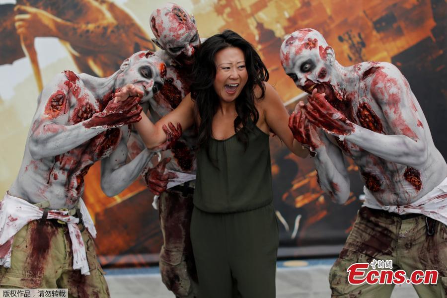 An attendee poses for a picture with a zombie at E3, the world\'s largest video game industry convention in Los Angeles, California, U.S., June 12, 2018. (Photo/Agencies)
