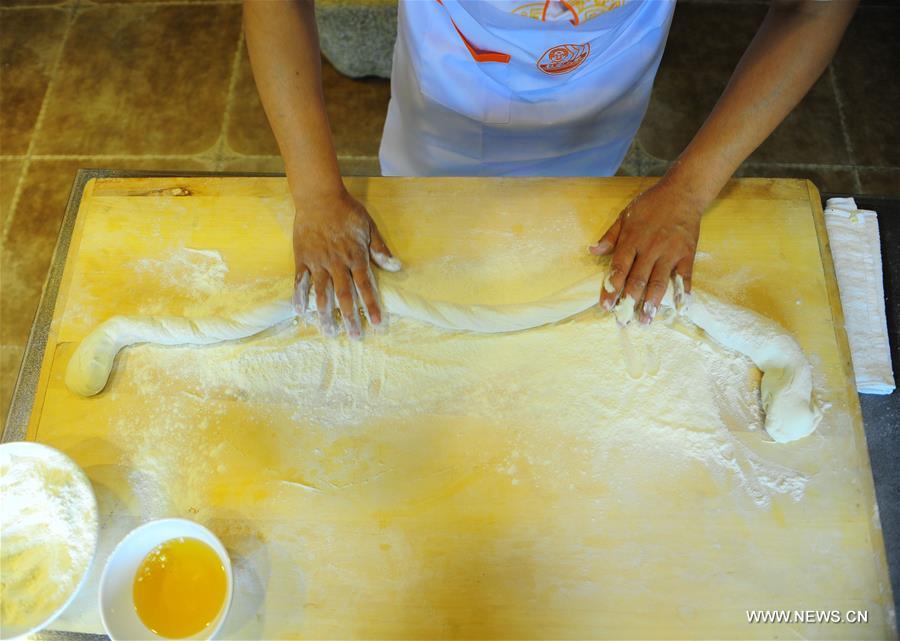 Quan Fujian prepares meals for customers at his restaurant in Yantai City, east China\'s Shandong Province, June 7, 2018. Fushan noodle is a traditional dish which is popular in Shandong Province. The noodle is hand pulled and cooked with various sauces and broths. The making of Fushan noodle was listed as a provincial intangible cultural heritage of Shandong in 2013. (Xinhua/Ren Pengfei)