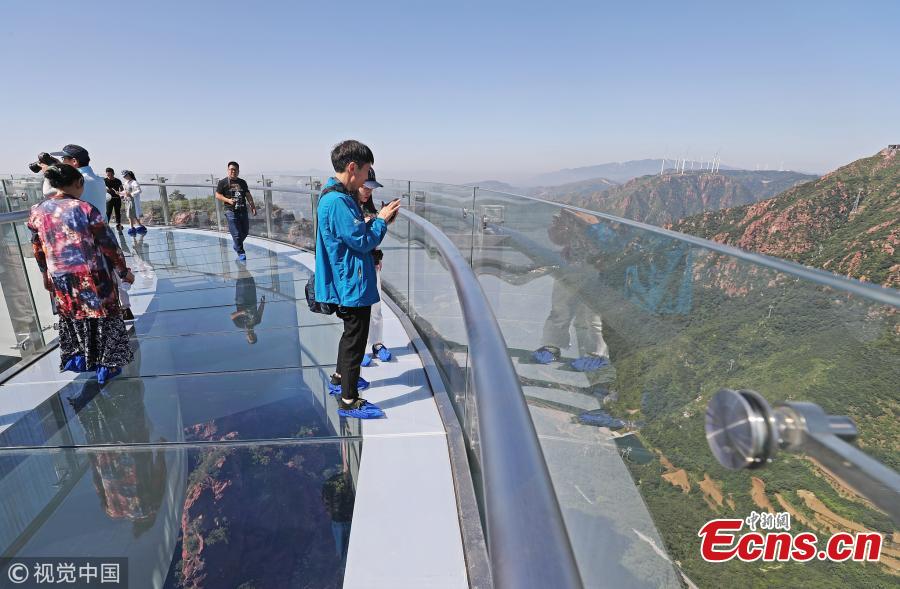 A skywalk is ready to open to the public in Fuxi Mountain scenic area in Xinmi City, Central China’s Henan Province, June 12, 2018. Built with 3,000 tons of steel, the U-shaped cantilevered glass walkway is 360 meters above the canyon floor and extends 30 meters past the cliff edge. (Photo/VCG)