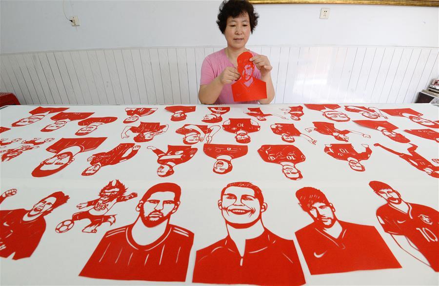 Craftswoman Feng Shiping makes paper-cutting works to greet the FIFA World Cup in Handan, north China\'s Hebei Province, June 12, 2018. (Xinhua/Hao Qunying)