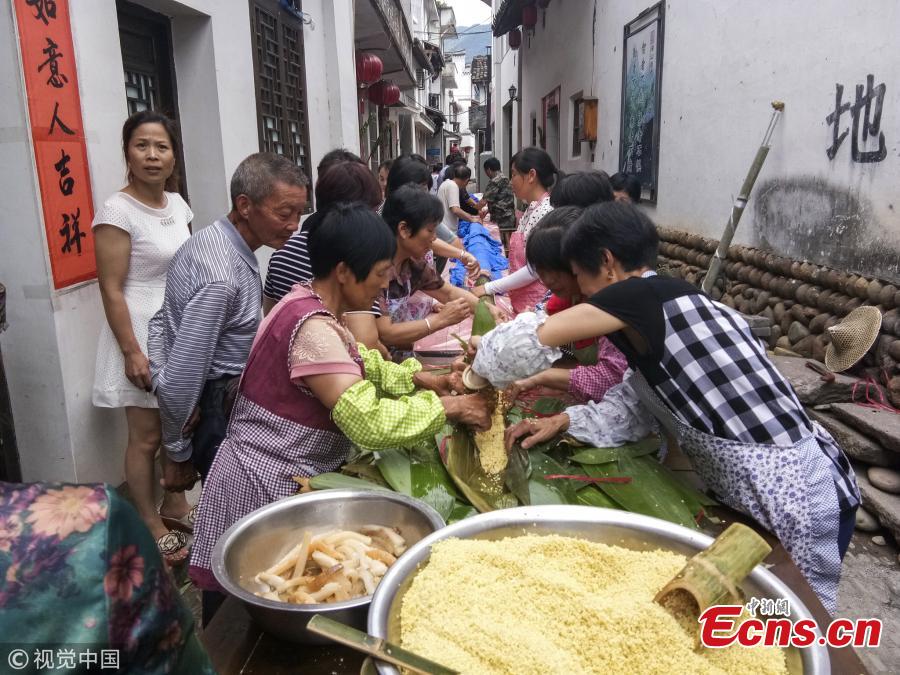 Villagers make a special zongzi - traditionally a pyramid-shaped dumpling made of glutinous rice wrapped in bamboo or reed leaves - to welcome the upcoming Dragon Boat Festival in Qiaoxi Village, Lishui City, East China’s Zhejiang Province, June 12, 2018. It took 50 people nearly 13 hours to make the cylinder zongzi, which was 20.18 meters long and 10 centimeters in diameter, and used 100 kilograms of sticky rice, 20 kilograms of preserved meat and thousands of leaves. (Photo/VCG)