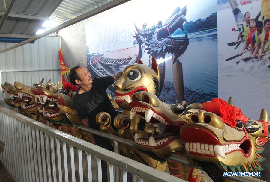 Folk artist Chen Bingshou displays the dragon head for the bow of a dragon boat in Daoxian County of Yongzhou City, central China\'s Hunan Province. Chen, 56, has been engaged in making dragon head for over 40 years. Every year, June is the busiest time for Chen as the demand for the dragon head is strong ahead of the dragon boat festival. Each dragon weighs about 15 kilograms and it takes Chen about 12 days to finish. (Xinhua/He Hongfu)