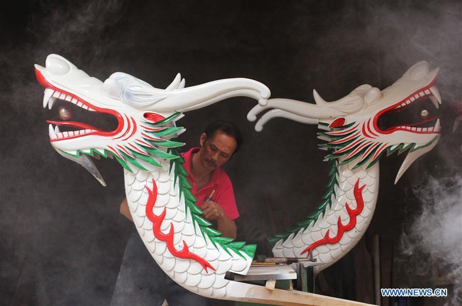 Folk artist Chen Bingshou displays a dragon boat model in Daoxian County of Yongzhou City, central China\'s Hunan Province. Chen, 56, has been engaged in making dragon head for over 40 years. Every year, June is the busiest time for Chen as the demand for the dragon head is strong ahead of the dragon boat festival. Each dragon weighs about 15 kilograms and it takes Chen about 12 days to finish. (Xinhua/He Hongfu)