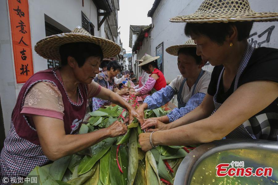 Villagers make a special zongzi - traditionally a pyramid-shaped dumpling made of glutinous rice wrapped in bamboo or reed leaves - to welcome the upcoming Dragon Boat Festival in Qiaoxi Village, Lishui City, East China’s Zhejiang Province, June 12, 2018. It took 50 people nearly 13 hours to make the cylinder zongzi, which was 20.18 meters long and 10 centimeters in diameter, and used 100 kilograms of sticky rice, 20 kilograms of preserved meat and thousands of leaves. (Photo/VCG)