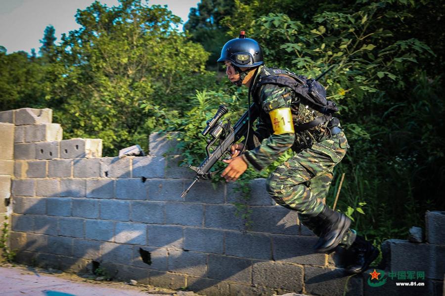 A soldier rushes through a gap in the wall in the operation area during the week-long rigorous training starting from June 11, 2018. (Photo/81.cn)
Soldiers from the Ningbo, Shaoxing, Zhoushan and Taizhou divisions of the Armed Police Force in East China’s Zhejiang Province took part in a week-long rigorous training program starting from June 11, 2018. The training included long marches, simulated battles, mountain climbing and a manhunt on the water.