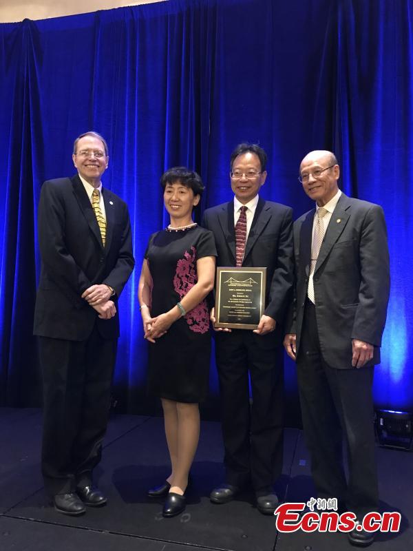 Xu Gongyi (2nd right), the deputy chief engineer of the China Railway Major Bridge Reconnaissance & Design Institute, poses with the IBC John A. Roebling medal, which was awarded for a lifetime achievement in bridge engineering at the 35th International Bridge Conference (IBC) in the United States. (Photo: China News Service/Wang Hu)