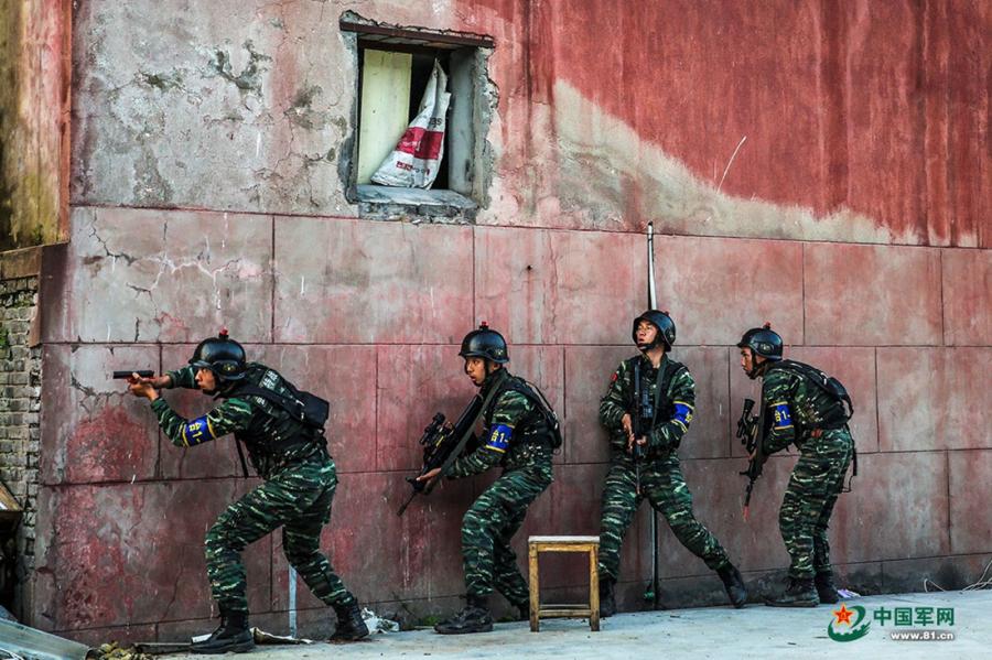 A group of soldiers cautiously move along a wall as they move around the operation area during the week-long rigorous training starting from June 11, 2018. (Photo/81.cn)