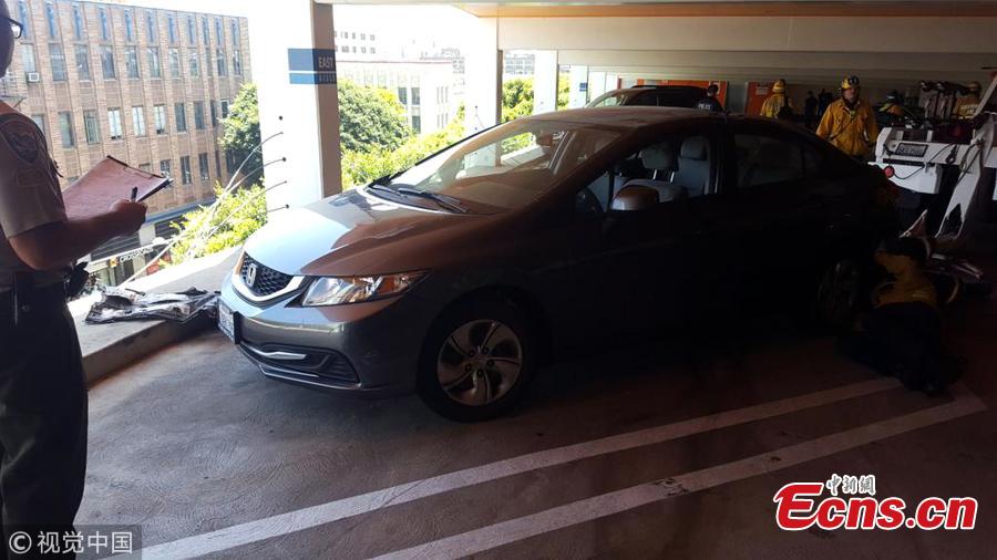 Photo taken on June 11, 2018 shows a tourist rescued a motorist whose car was left dangling off the fifth floor of a car park in Santa Monica, California. The female driver, reportedly in her 60s, came close to driving off the edge of the building after accidentally pushing the accelerator, local media reported. (Photo/Agencies)