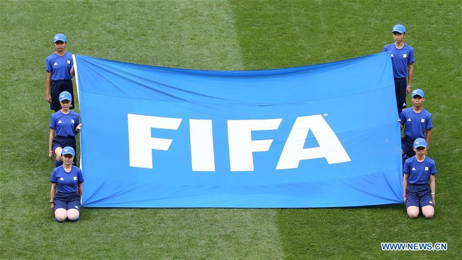 Chinese caddies hold a FIFA flag before the opening match of the 2018 FIFA World Cup in Moscow, Russia, on June 14, 2018. (Xinhua/Cao Can)