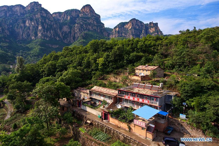 Aerial photo taken on June 12, 2018 shows buildings for farm tourism in Shenlongwan Village in Changzhi City, north China\'s Shanxi Province. A 1,526-meter-long road was built along the cliffs to connect isolated Shenlongwan to the outside. The construction of this miraculous road lasted for fifteen years from 1985 to 2000, and was built purely by villagers of Shenlongwan. Thanks to this road, villagers here now cast off poverty by developing tourism. (Xinhua/Cao Yang)