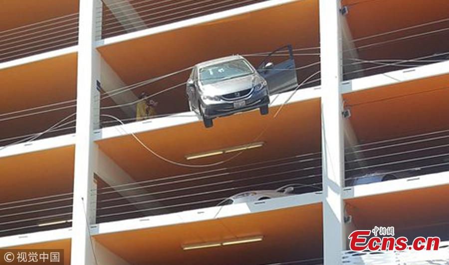 Photo taken on June 11, 2018 shows a tourist rescued a motorist whose car was left dangling off the fifth floor of a car park in Santa Monica, California. The female driver, reportedly in her 60s, came close to driving off the edge of the building after accidentally pushing the accelerator, local media reported. (Photo/Agencies)