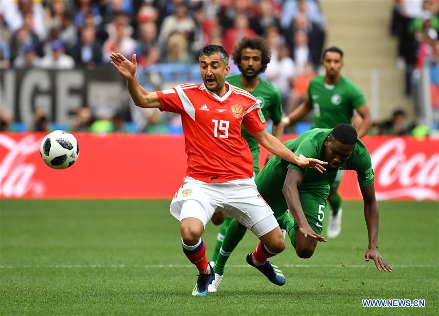 Russia\'s Alexandr Samedov (L) vies with Saudi Arabia\'s Omar Othman during the opening match of the 2018 FIFA World Cup in Moscow, Russia, on June 14, 2018. (Xinhua/Cao Can)