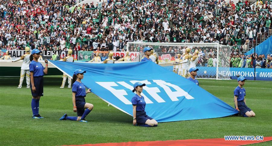 Chinese caddies hold a FIFA flag before the opening match of the 2018 FIFA World Cup in Moscow, Russia, on June 14, 2018. (Xinhua/Xu Zijian)