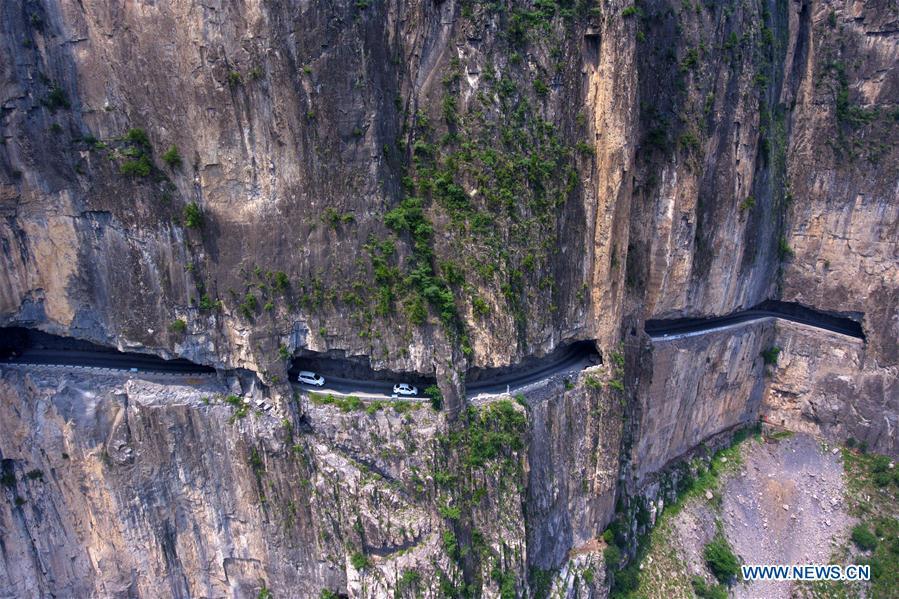 Aerial photo taken on June 13, 2018 shows cars running on a road in cliffs in Shenlongwan Village in Changzhi City, north China\'s Shanxi Province. A 1,526-meter-long road was built along the cliffs to connect isolated Shenlongwan to the outside. The construction of this miraculous road lasted for fifteen years from 1985 to 2000, and was built purely by villagers of Shenlongwan. Thanks to this road, villagers here now cast off poverty by developing tourism. (Xinhua/Cao Yang)