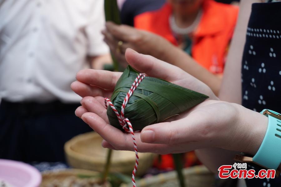 A group of overseas students and expats gathered at Huishan economic development zone in Wuxi, Jiansu Province to learn how to make Zongzi, the palm-sized snack made of glutinous rice wrapped in reed leaves, June 15, 2018, to celebrate the upcoming Dragon Boat Festival. (Photo: China News Service/Sun Quan)