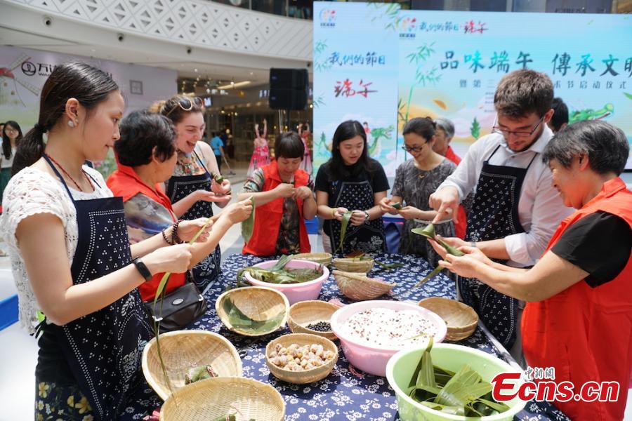 A group of overseas students and expats gathered at Huishan economic development zone in Wuxi, Jiansu Province to learn how to make Zongzi, the palm-sized snack made of glutinous rice wrapped in reed leaves, June 15, 2018, to celebrate the upcoming Dragon Boat Festival. (Photo: China News Service/Sun Quan)