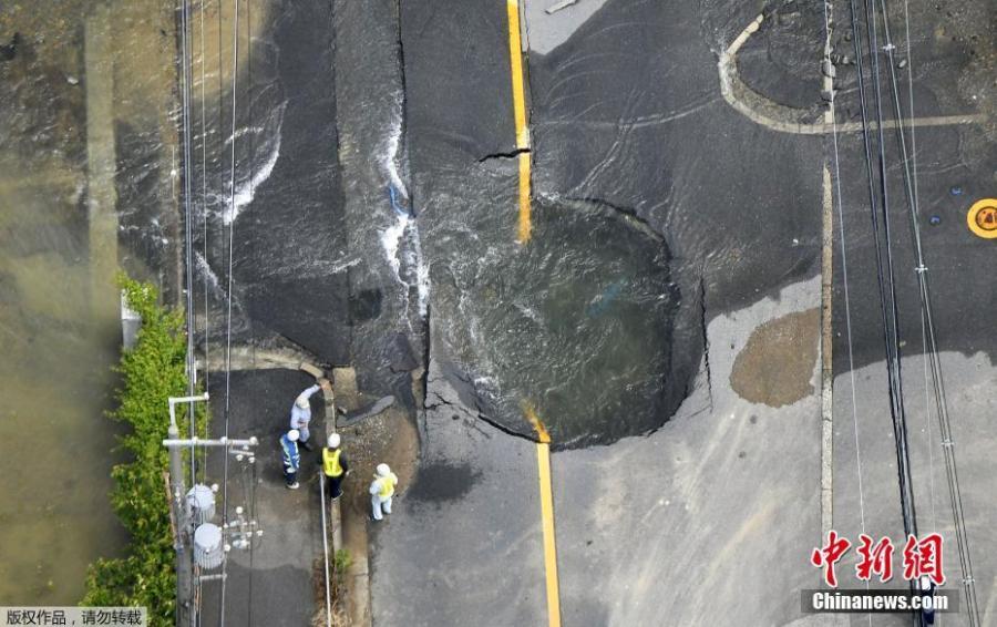 Water flows out from cracks in a road damaged by an earthquake in Takatsuki, Osaka prefecture, western Japan, June 18, 2018. (Photo/China News Service)