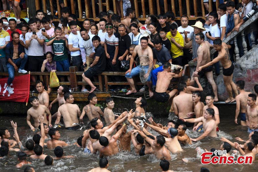 Participants compete to grab ducks during a folk event to celebrate the Dragon Boat Festival in the Tuojiang River in Phoenix Ancient Town, Central China’s Hunan Province, June 18, 2018. The duck-chasing tradition in the river has a 100-year history. (Photo: China News Service/Yang Huafeng)