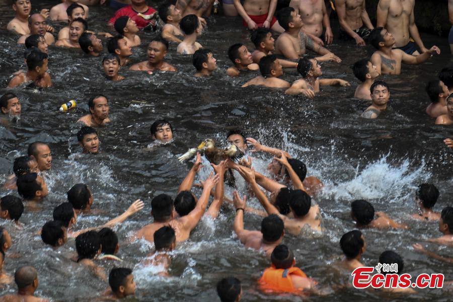 Participants compete to grab ducks during a folk event to celebrate the Dragon Boat Festival in the Tuojiang River in Phoenix Ancient Town, Central China’s Hunan Province, June 18, 2018. The duck-chasing tradition in the river has a 100-year history. (Photo: China News Service/Yang Huafeng)