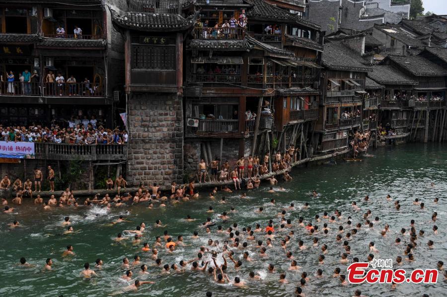Participants compete to grab ducks during a folk event to celebrate the Dragon Boat Festival in the Tuojiang River in Phoenix Ancient Town, Central China’s Hunan Province, June 18, 2018. The duck-chasing tradition in the river has a 100-year history. (Photo: China News Service/Yang Huafeng)