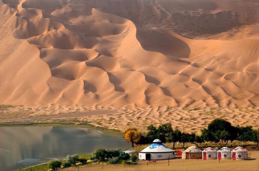 Scenery from the Badain Jaran desert in Alshaa league, North China\'s Inner Mongolia autonomous region. Sapphire-blue lakes coexist with high and low sand hills, presenting an interesting blend of barren and lush landscapes. (Photo/China Daily)