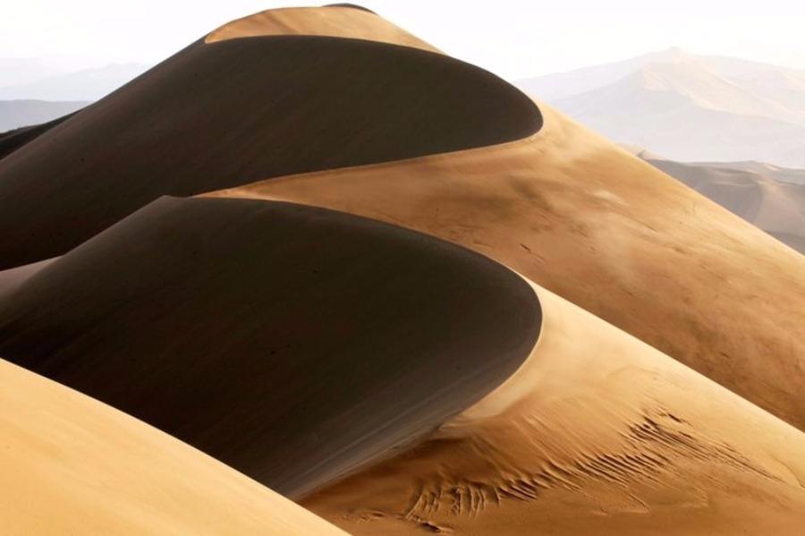 Scenery from the Badain Jaran desert in Alshaa league, North China\'s Inner Mongolia autonomous region. Sapphire-blue lakes coexist with high and low sand hills, presenting an interesting blend of barren and lush landscapes. (Photo/China Daily)