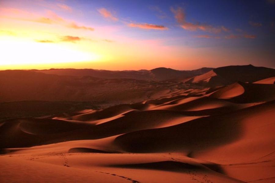 Scenery from the Badain Jaran desert in Alshaa league, North China\'s Inner Mongolia autonomous region. Sapphire-blue lakes coexist with high and low sand hills, presenting an interesting blend of barren and lush landscapes. (Photo/China Daily)
