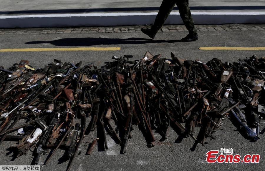 A Brazilian Army soldier walks past by guns seized from criminals by armed forces before being destroyed in Rio de Janeiro, Brazil, June 20, 2018. The Brazilian army invited the media Wednesday to observe the destruction of 8,549 firearms seized from criminals, handed in voluntarily, or retired from police arsenals. (Photo/Agencies)