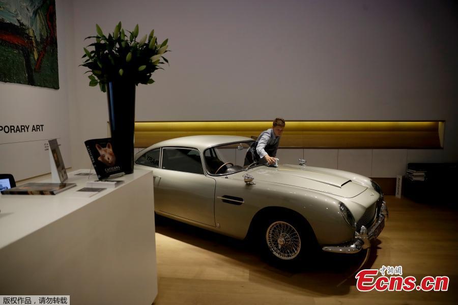 A staff member from the Bonhams motor car department poses for photographers with the 1965 Aston Martin DB5 driven by actor Pierce Brosnan in his role as James Bond in the 1995 movie GoldenEye during a photocall at premises of Bonhams auction house in London, June 19, 2018. The car is estimated to fetch between 1.2 million and 1.6 million pounds ($1.6 million to $2.1 million) in a sale on July 13. (Photo/Agencies)