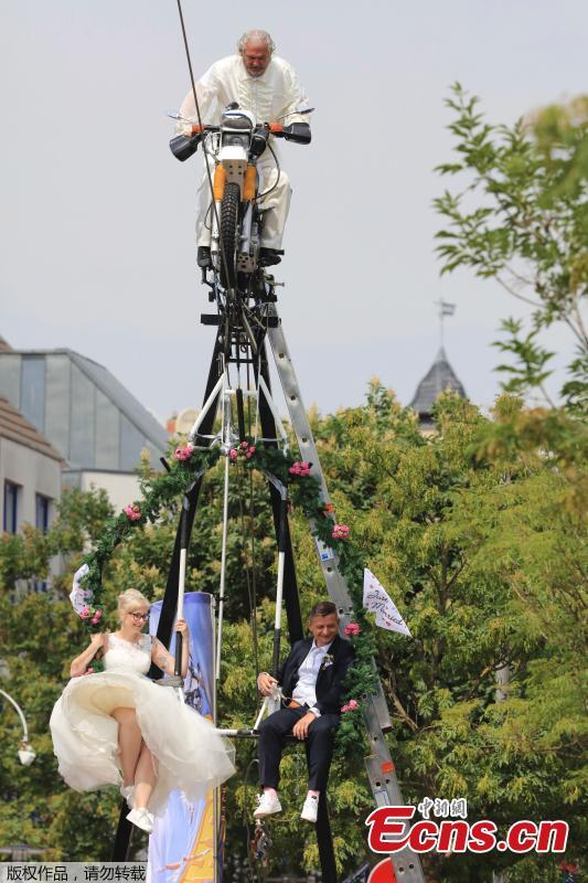The high-wire artist Falko Traber drives the bridal couple Nicole Backhaus and Jens Knorr during the wedding ceremony atop a tightrope in Stassfurt, Germany, June 16, 2018. (Photo/Agencies)