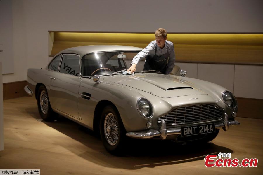 A staff member from the Bonhams motor car department poses for photographers with the 1965 Aston Martin DB5 driven by actor Pierce Brosnan in his role as James Bond in the 1995 movie GoldenEye during a photocall at premises of Bonhams auction house in London, June 19, 2018. The car is estimated to fetch between 1.2 million and 1.6 million pounds ($1.6 million to $2.1 million) in a sale on July 13. (Photo/Agencies)