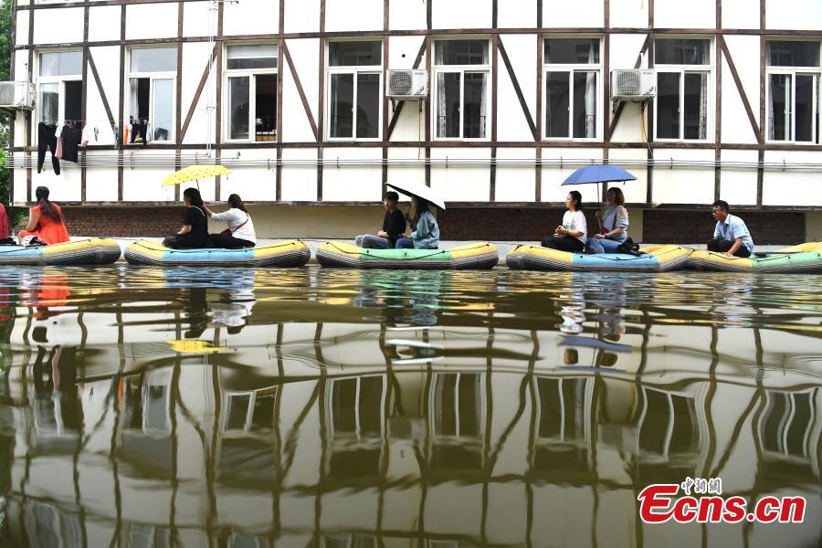 Tourists take boats on an artificial canal during their visit to a wine town in Fuling District, Southwest China’s Chongqing Municipality, June 20, 2018. The five-kilometer-long canal includes a section that passes through a building. (Photo: China News Service/Chen Chao)