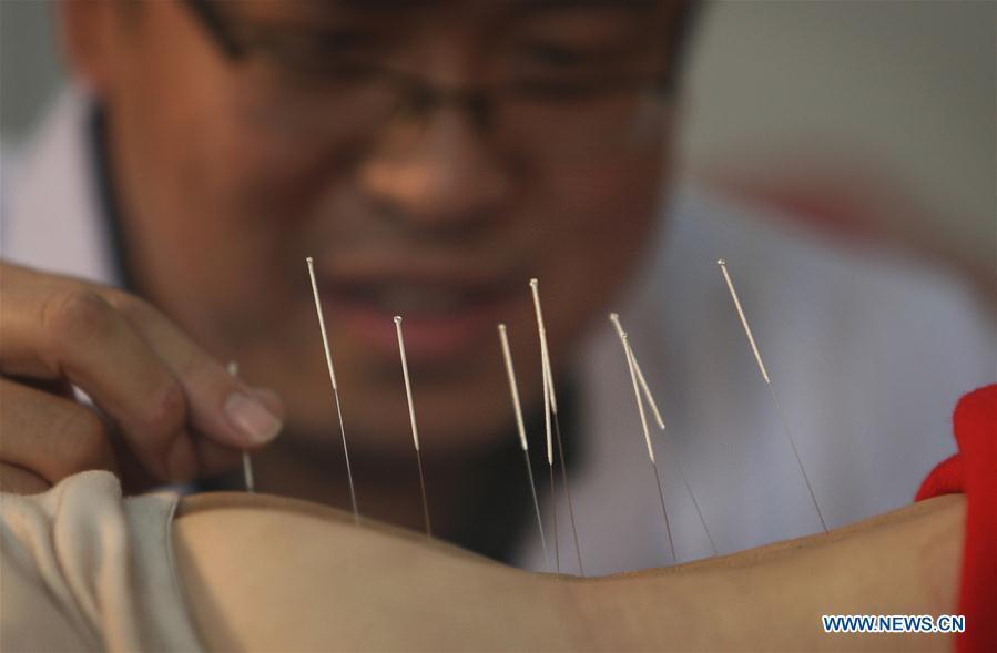 File photo taken on March 11, 2011 shows a doctor practicing acupuncture at a clinic in Beijing, capital of China. Traditional Chinese medicine (TCM), one of the world\'s oldest forms of medicine with different practices including acupuncture, bee-sting therapy, cupping, moxibustion, scrapping, tui na (Chinese therapeutic massage), still prevails in the modern society after thousands of years of evolution, during which generations have restored and maintained health depending on it. The World Health Organization disease index was updated to include references to traditional Chinese medicine for the first time in June 2018. (Photo/Xinhua)