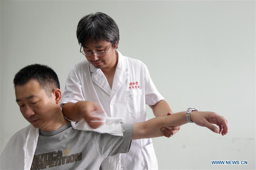 File photo taken on July 29, 2010 shows a doctor providing tui na treatment for a patient at a hospital of the Tongrentang, a renowned traditional Chinese medicine maker, in Beijing, capital of China. Traditional Chinese medicine (TCM), one of the world\'s oldest forms of medicine with different practices including acupuncture, bee-sting therapy, cupping, moxibustion, scrapping, tui na (Chinese therapeutic massage), still prevails in the modern society after thousands of years of evolution, during which generations have restored and maintained health depending on it. The World Health Organization disease index was updated to include references to traditional Chinese medicine for the first time in June 2018. (Xinhua/Xing Guangli)