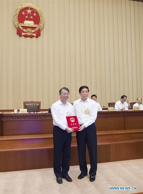 Li Zhanshu (R, front), chairman of the National People\'s Congress (NPC) Standing Committee, grants certificate of appointment to a member of the Hong Kong basic law committee of the NPC Standing Committee during a bimonthly session of the 13th NPC Standing Committee at the Great Hall of the People in Beijing, capital of China, June 22, 2018. The bimonthly session concluded here on Friday. (Xinhua/Li Tao)