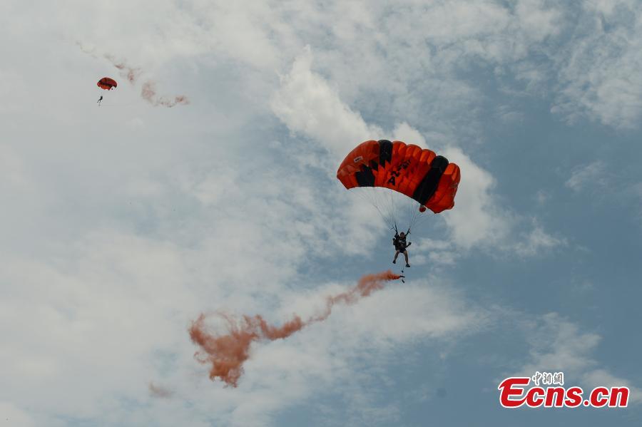 Shi Chunyan, a female BASE jumper, successfully jumps from a helicopter at a height of 300 meters at a theme park in Zhuzhou City, Central China’s Hunan Province, June 23, 2018. When the helicopter reached the planned height, she jumped off and landed safely using a parachute in the 60-second challenge. (Photo: China News Service/Yang Huafeng)