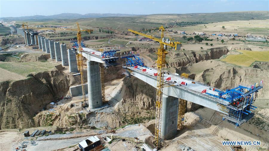 In this aerial photo taken on June 23, 2018, workers construct a bridge in the Gansu-Ningxia section of the Yinchuan-Xi\'an high-speed railway in northwest China\'s Ningxia Hui Autonomous Region. The 617-kilometer high-speed railway is scheduled to start operation by the end of 2020 with a design speed of 250 kilometers per hour. (Xinhua/Wang Peng)