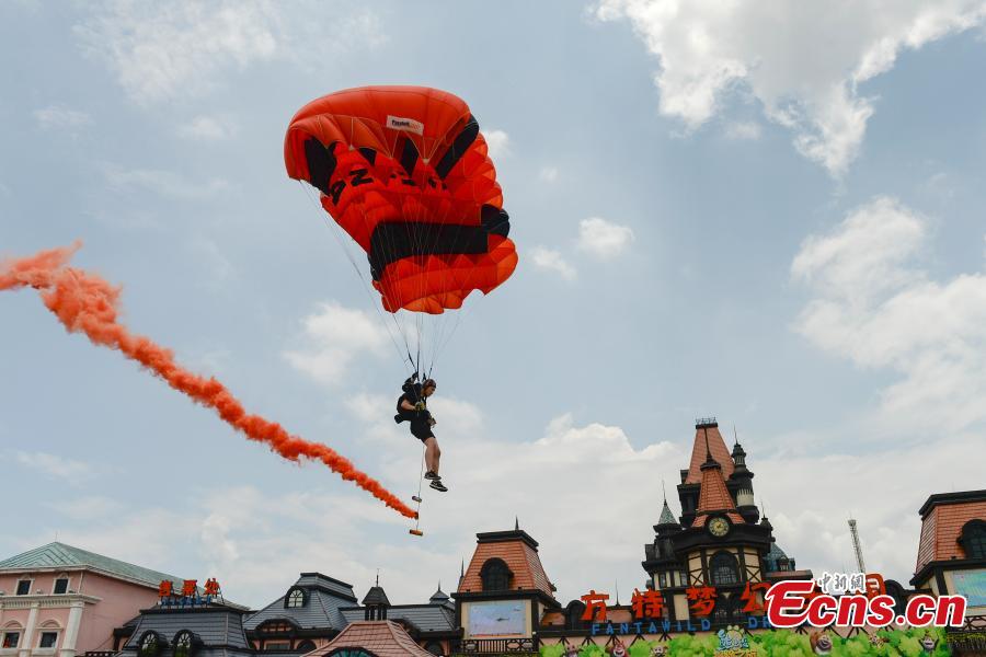 Shi Chunyan, a female BASE jumper, successfully jumps from a helicopter at a height of 300 meters at a theme park in Zhuzhou City, Central China’s Hunan Province, June 23, 2018. When the helicopter reached the planned height, she jumped off and landed safely using a parachute in the 60-second challenge. (Photo: China News Service/Yang Huafeng)