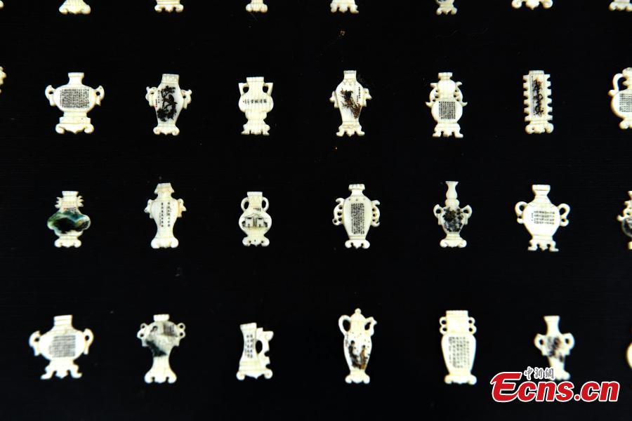 Pan Qihui shows miniature calligraphy he carved at an exhibition in Chongqing, June 23, 2018. The smallest characters carved by Pan are as thin as a hair and a magnifying glass is needed to see them. (Photo: China News Service/Chen Chao)