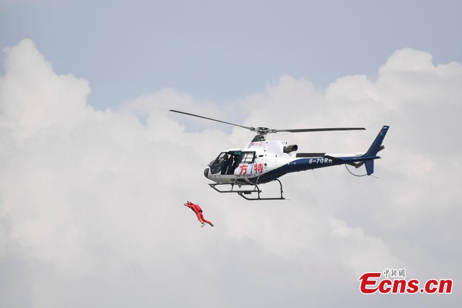 Shi Chunyan, a female BASE jumper, successfully jumps from a helicopter at a height of 300 meters at a theme park in Zhuzhou City, Central China’s Hunan Province, June 23, 2018. When the helicopter reached the planned height, she jumped off and landed safely using a parachute in the 60-second challenge. (Photo: China News Service/Yang Huafeng)