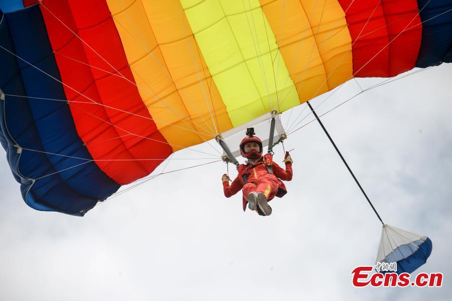 Shi Chunyan, a female BASE jumper, successfully jumps from a helicopter at a height of 300 meters at a theme park in Zhuzhou City, Central China’s Hunan Province, June 23, 2018. When the helicopter reached the planned height, she jumped off and landed safely using a parachute in the 60-second challenge. (Photo: China News Service/Yang Huafeng)